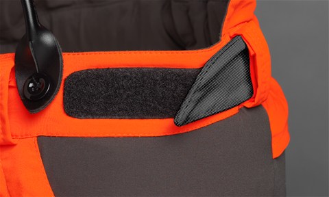 Melnas ar oranžu Husqvarna jostas aizsargbikses, modelis ''Technical Extreme'', jostasvieta, kas ir regulējama ar lipekli